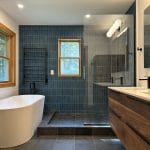 Modern bathroom with a freestanding tub, glass shower, and wood accents, ideal for bathroom renovation, construction, and remodeling services in bathroom remodeling ideas for 2025