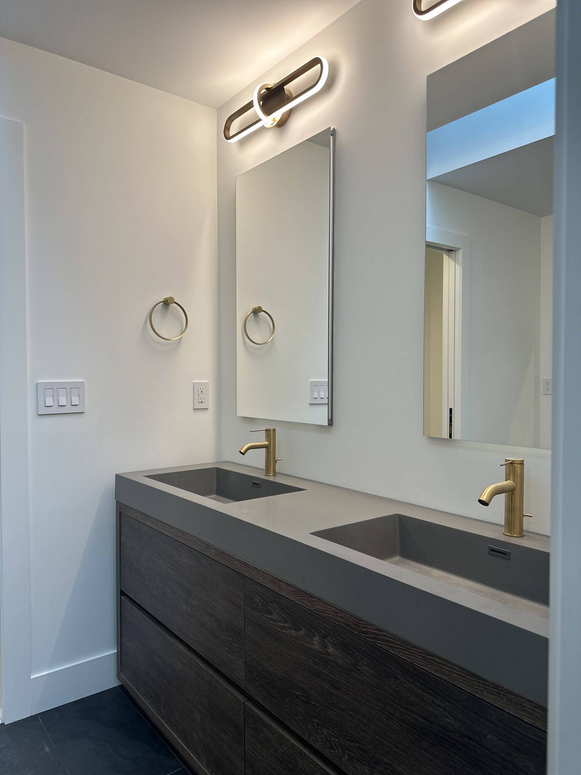 dark tile bathroom sink with golden faucets